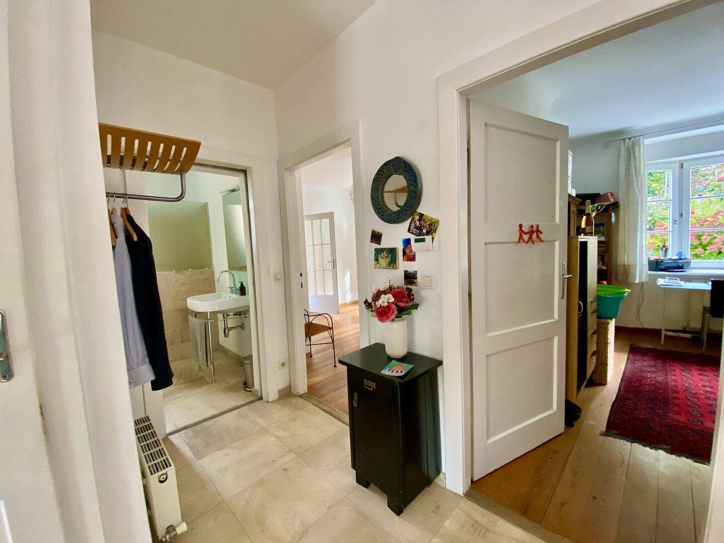 Heller Flur mit Fliesenboden, Garderobe und Zugang zu weiteren Räumen.