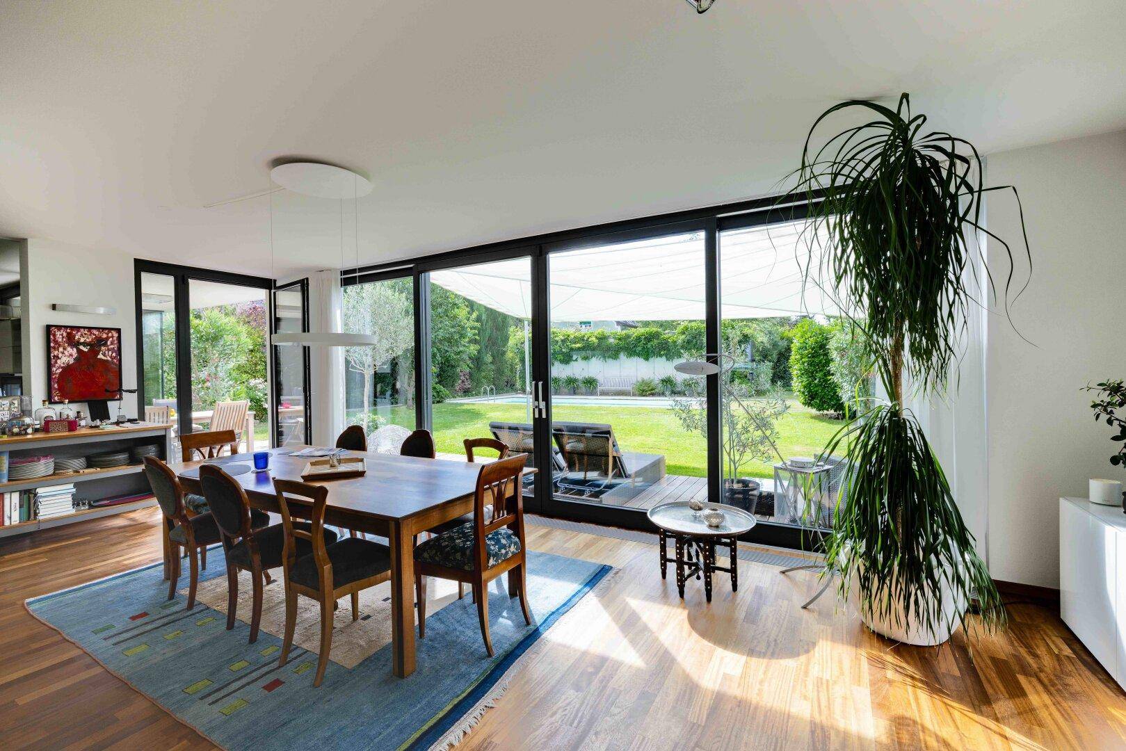 Geräumiger Essbereich mit Holztisch, Parkettboden und großen Fenstern zum Garten.