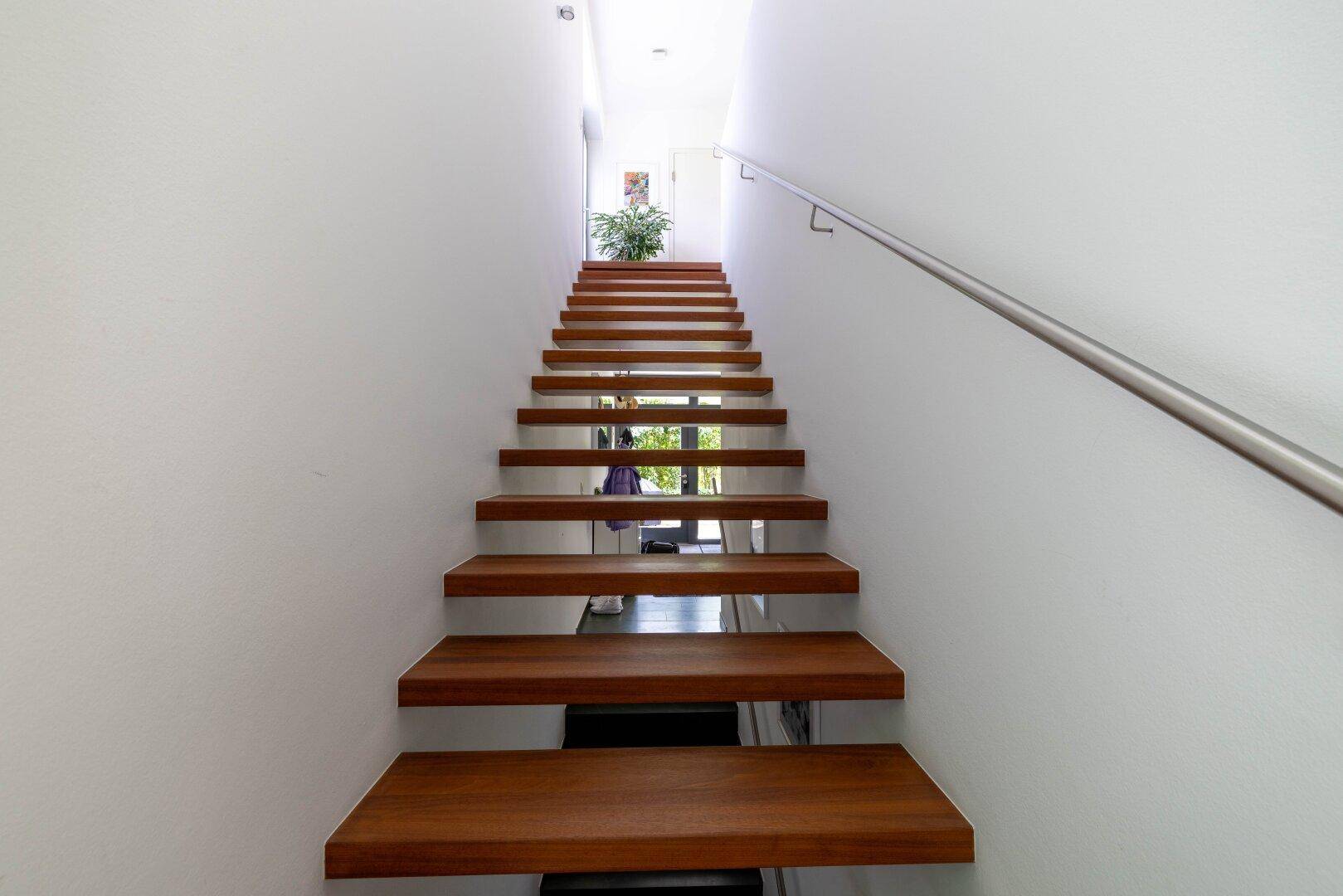 Moderne Holztreppe mit schwebenden Stufen und minimalistischem Design in hellem Ambiente.