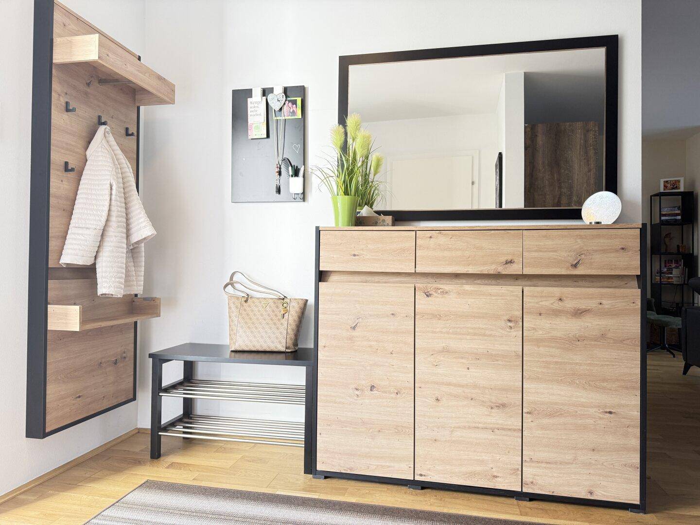Detailansicht des Flurs mit stilvoller Garderobe, Schuhschrank und großem Wandspiegel.