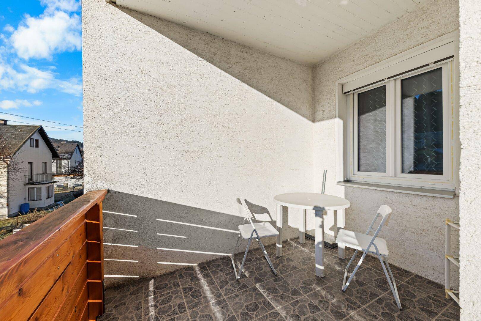 Kleiner Balkon mit Fliesenboden und Sitzgelegenheiten, ideal für entspannte Stunden im Freien.