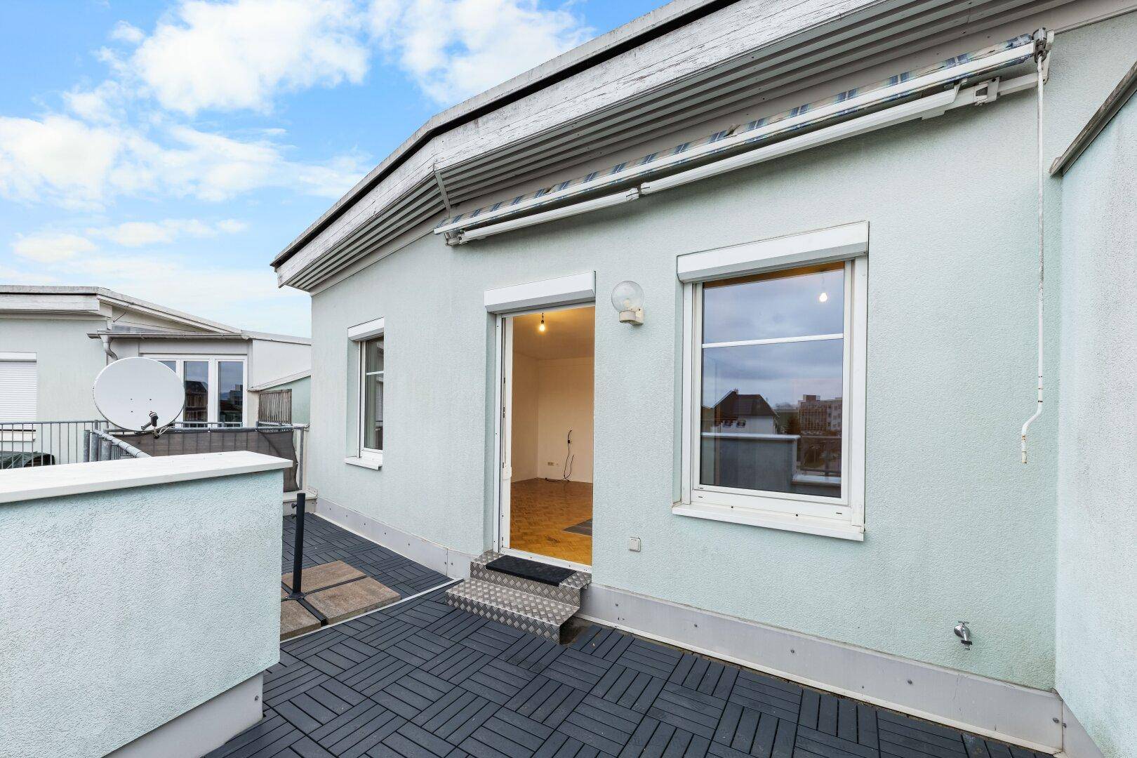 Zugang zur Wohnung von der Dachterrasse mit Rollläden an den Fenstern.