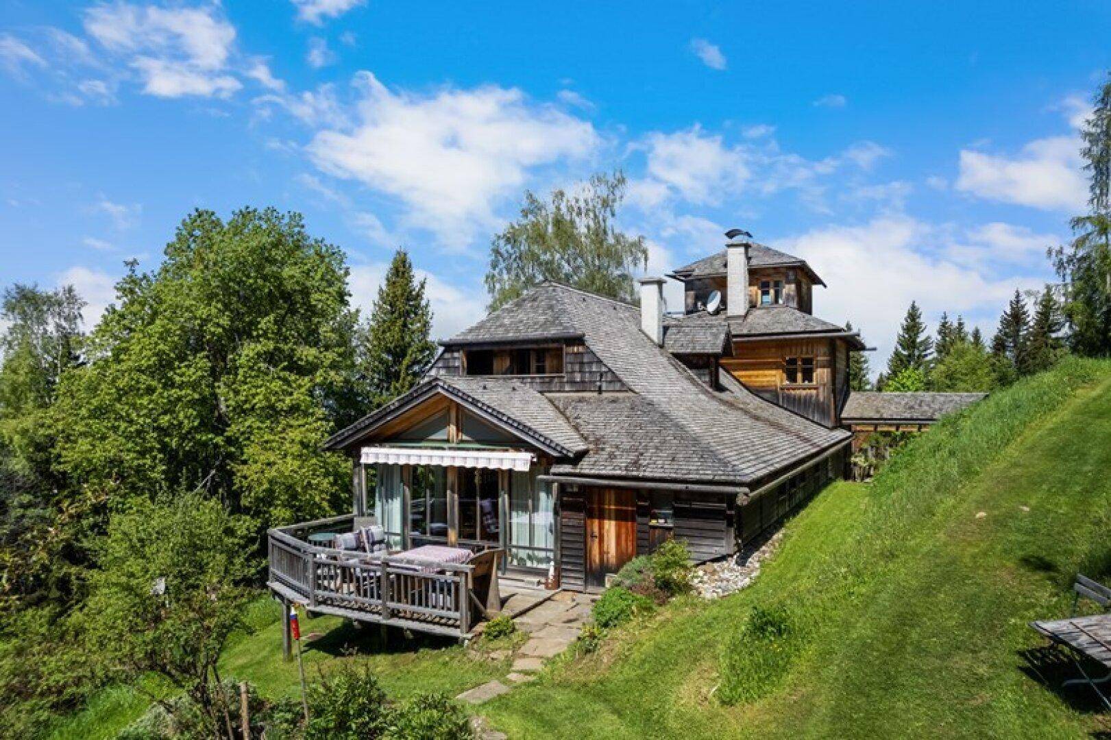 Gemütlicher Balkon am Holzhaus mit Sitzgelegenheiten und weitem Blick in die Natur.