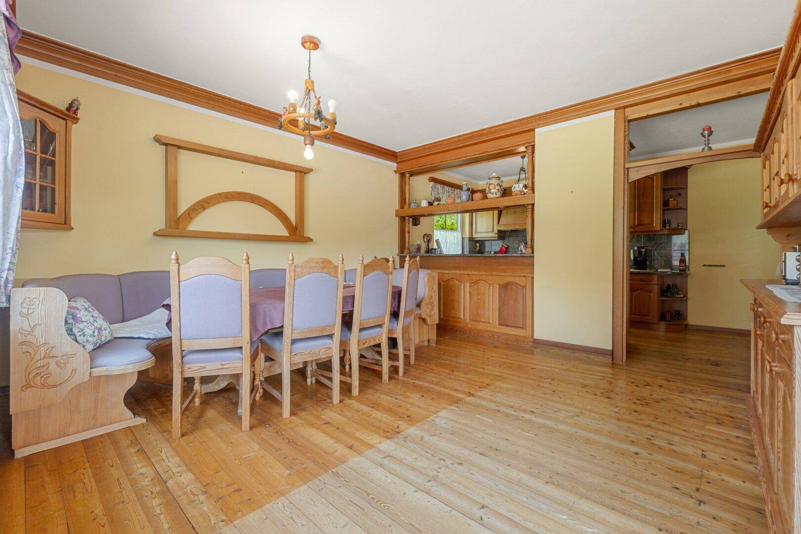 Gemütlicher Essbereich mit Holzboden und Durchreiche zur Küche, ideal für Familienessen.