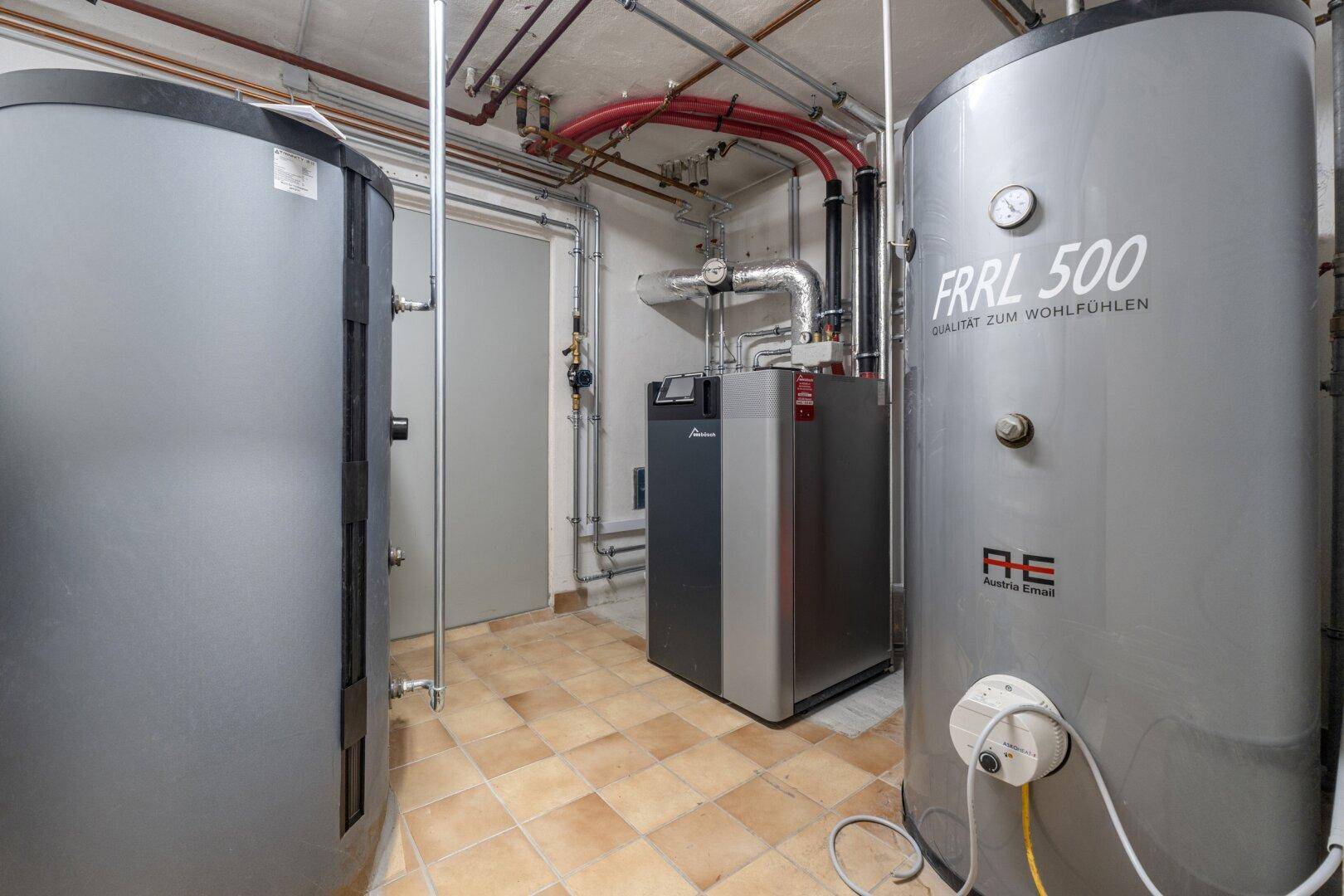Heizungsraum mit modernen Heizkesseln und Warmwasserspeichern für das gesamte Haus.