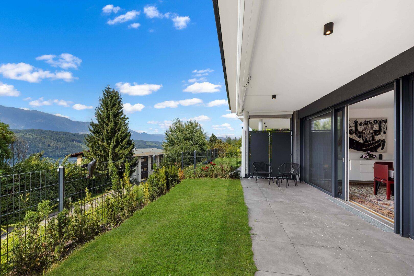 Große Terrasse mit Rasenfläche und atemberaubendem Blick auf die umliegende Berglandschaft.