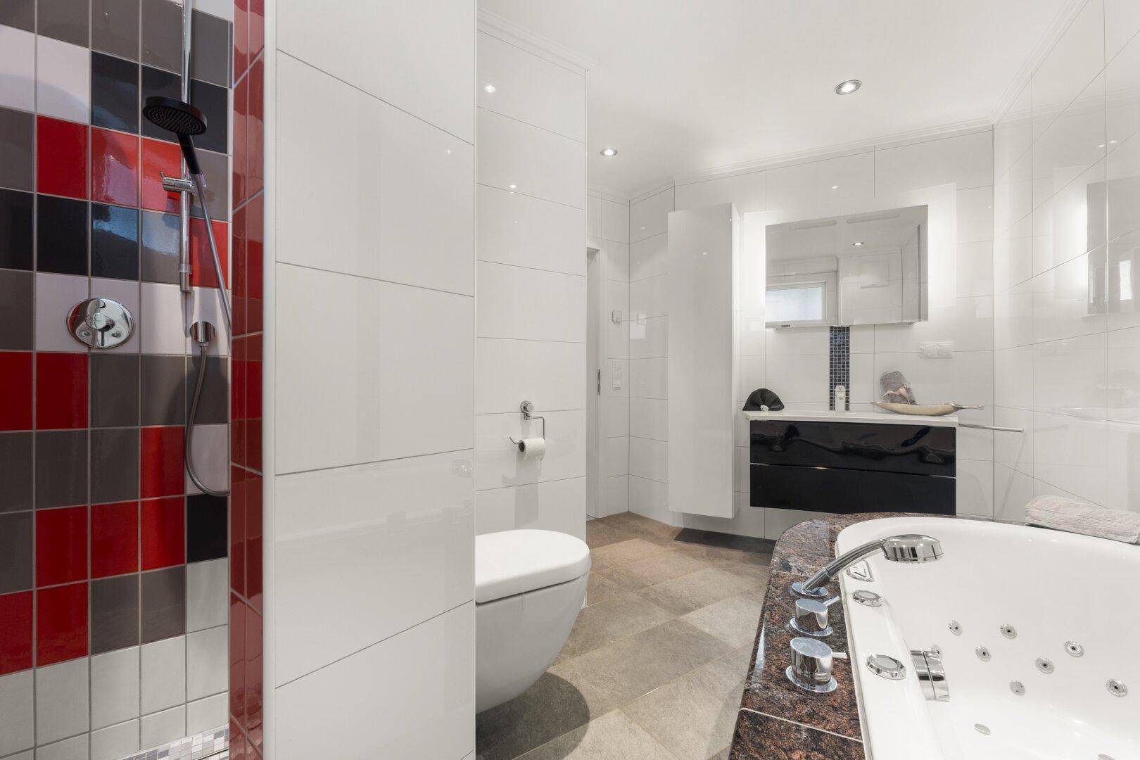 Modernes Badezimmer mit farbiger Duschkabine, Whirlpool-Badewanne und Doppelwaschbecken.