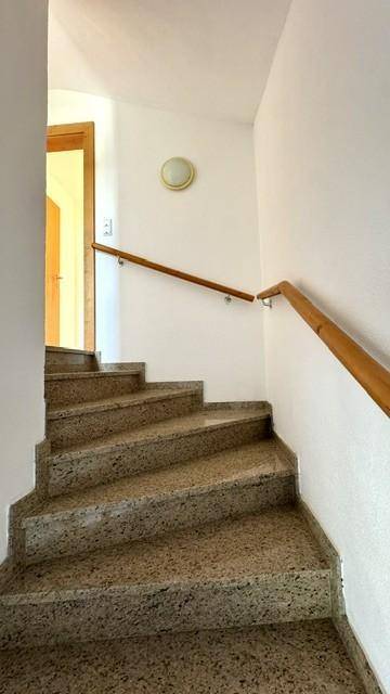 Treppenhaus mit Steinstufen und Holzgeländer, das die verschiedenen Etagen verbindet.