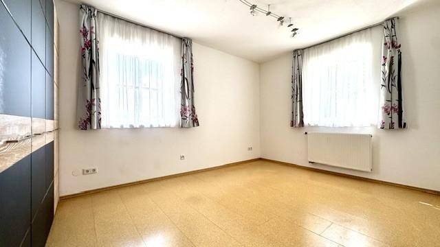 Schlafzimmer mit hellem Boden, großen Fenstern und ausreichend Platz für Möbel.