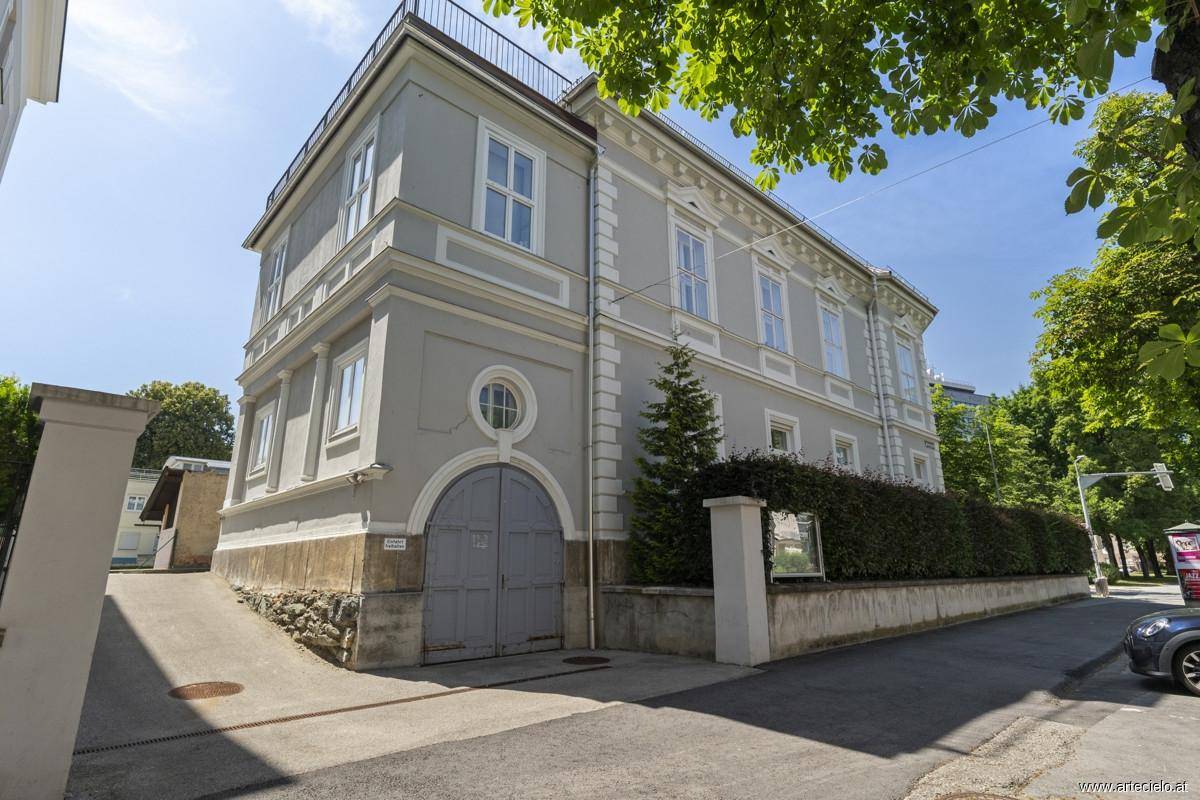 Historisches Gebäude mit klassischer Architektur und gepflegter Fassade unter blauem Himmel.