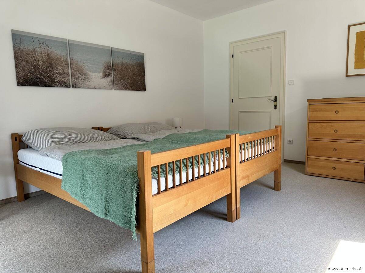 Gemütliches Schlafzimmer mit zwei Einzelbetten und Holzkommode, ideal für Gäste.