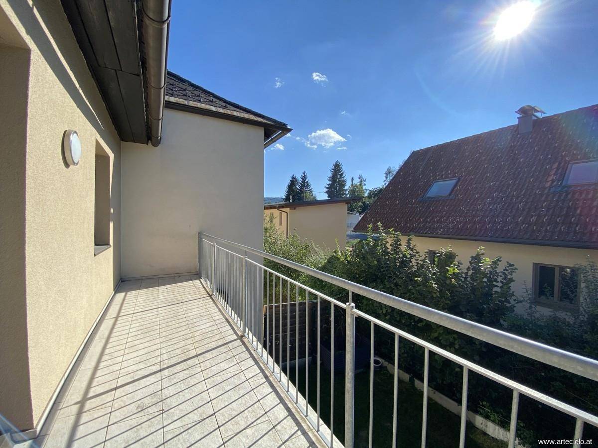Heller Balkon mit Fliesenboden und Metallgeländer, bietet einen weiten Blick auf die Umgebung.