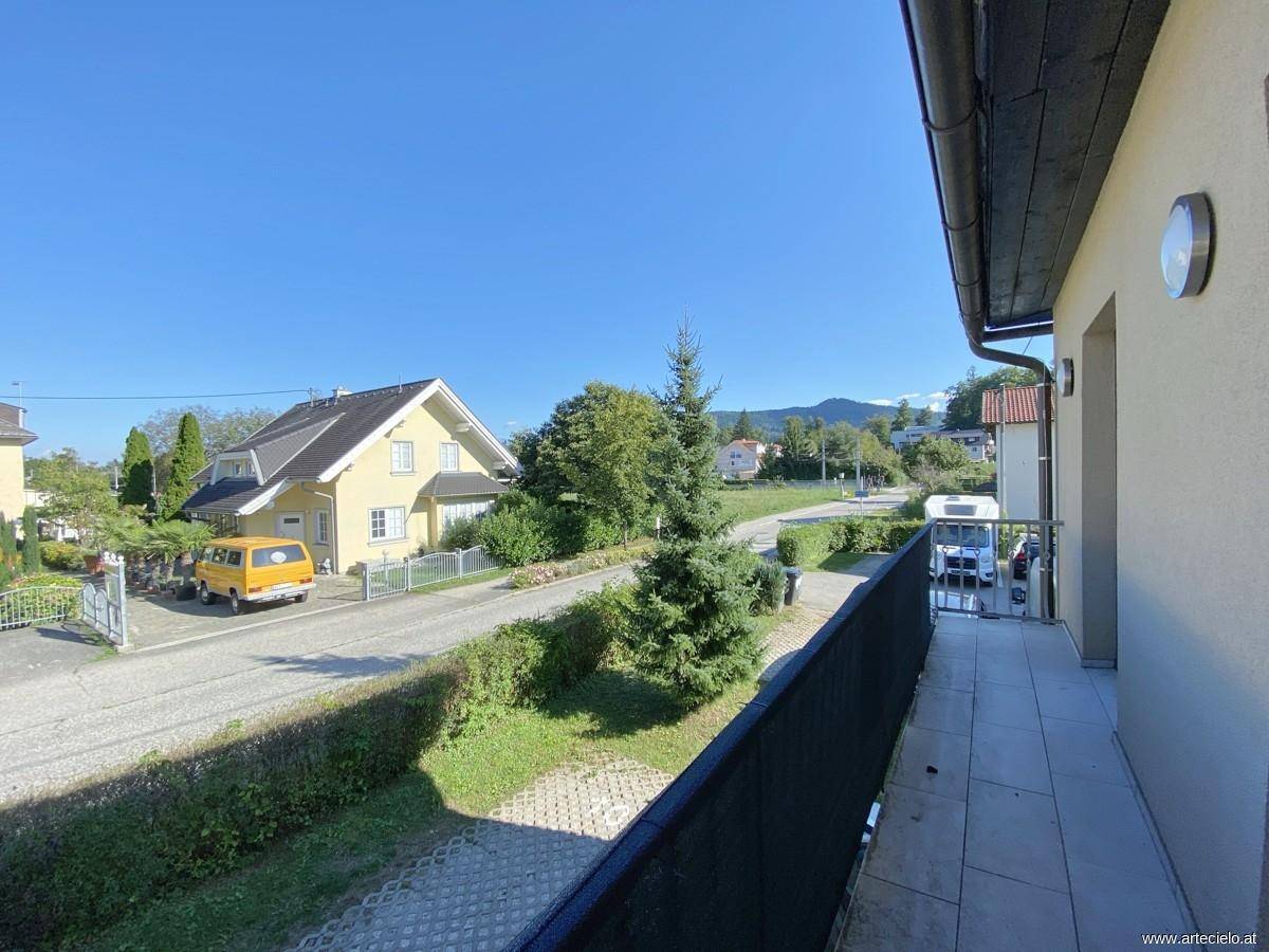 Balkon mit Fliesenboden und Blick auf die Straße sowie die umliegende Berglandschaft.