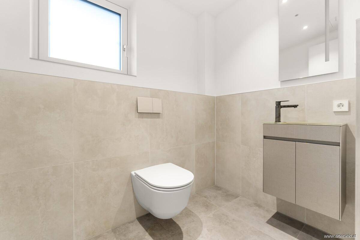 Modernes Gäste-WC mit Wand-WC, Waschbecken und Fenster.