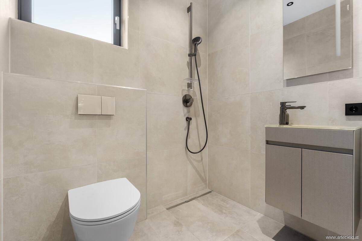 Modernes Badezimmer mit ebenerdiger Dusche, Wand-WC und Fenster.