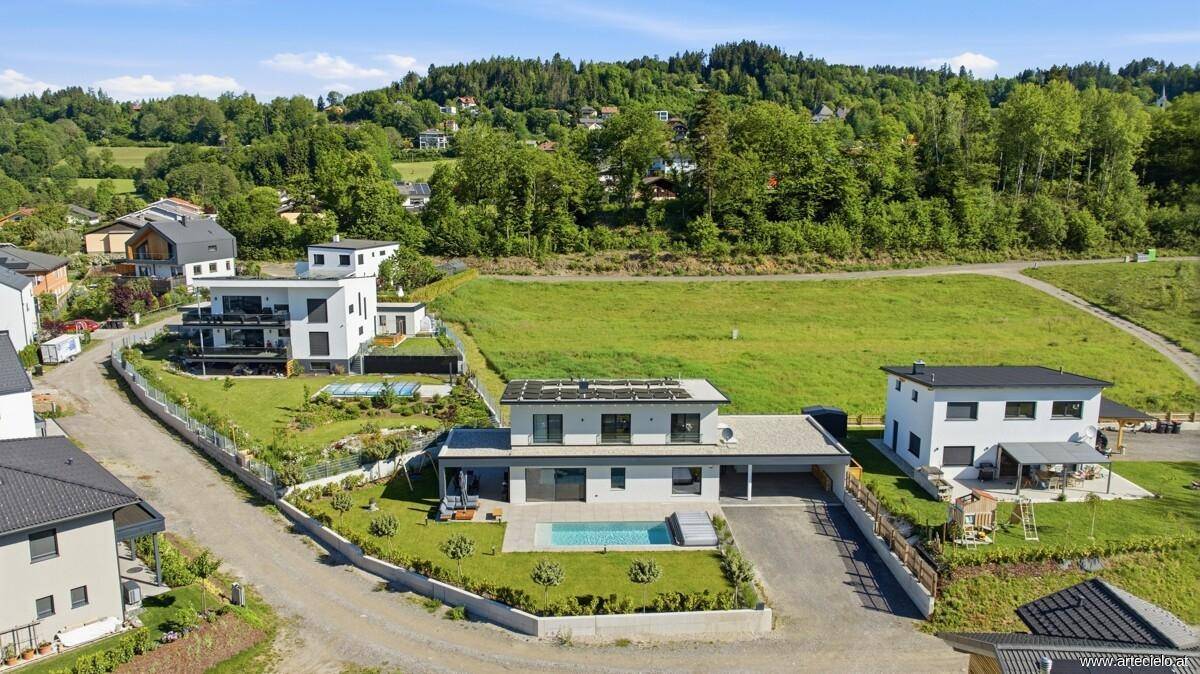 Luftaufnahme des modernen Hauses mit Pool, Solaranlage und weitläufigem Grundstück.