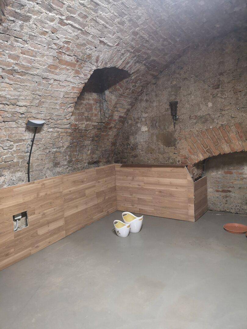 Kellerraum mit historischen Ziegelgewölben, neuem Boden und teilweise installierter Holzverkleidung.