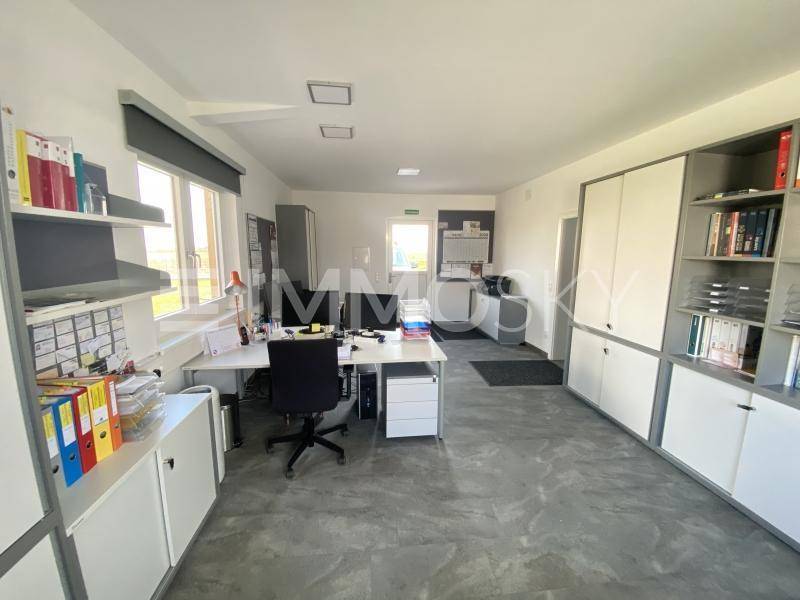 Helles und funktionales Büro mit mehreren Arbeitsplätzen und integrierten Schränken.