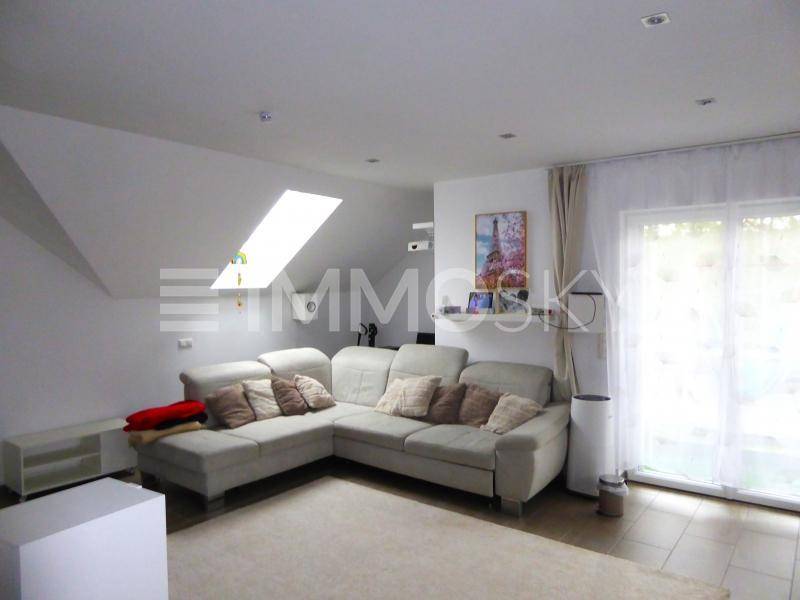 Gemütliches Wohnzimmer mit großem Sofa, Dachfenster und Zugang zum Außenbereich.