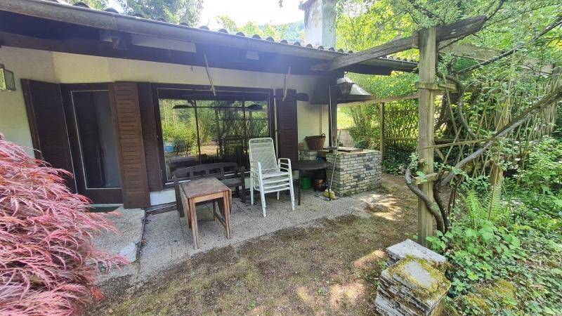 Gemütliche Terrasse mit Gartenmöbeln und gemauertem Grillbereich, umgeben von viel Grün.
