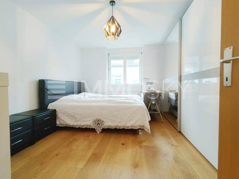 Schlafzimmer mit Doppelbett, Holzfußboden und großem Spiegelschrank.