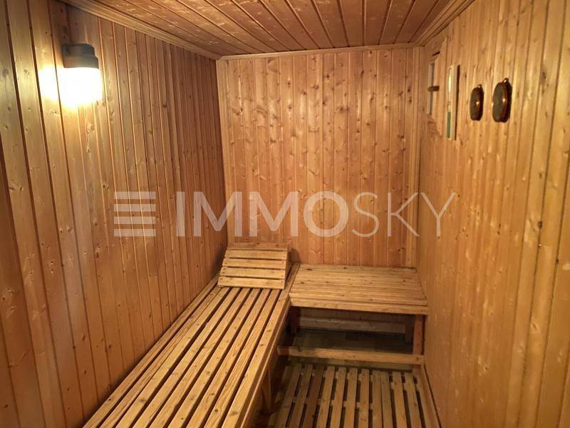Holzvertäfelte Sauna mit Sitzbänken für entspannende Momente und Wohlbefinden.