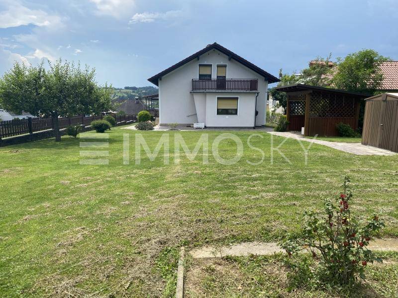 Großer, gepflegter Garten hinter dem Haus mit Rasenfläche, Bäumen und Gartenhaus.