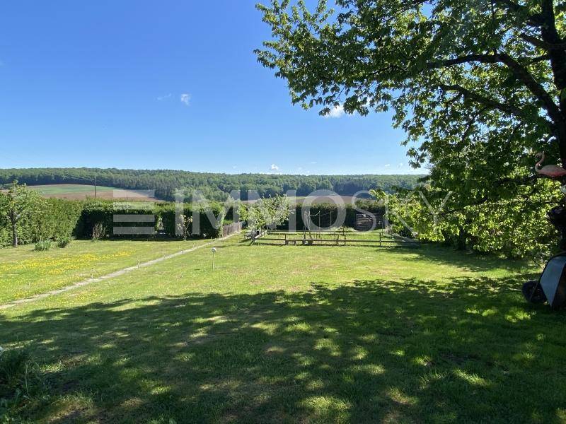 Großer, gepflegter Garten mit Rasenfläche und weitem Blick über die umliegende Landschaft.