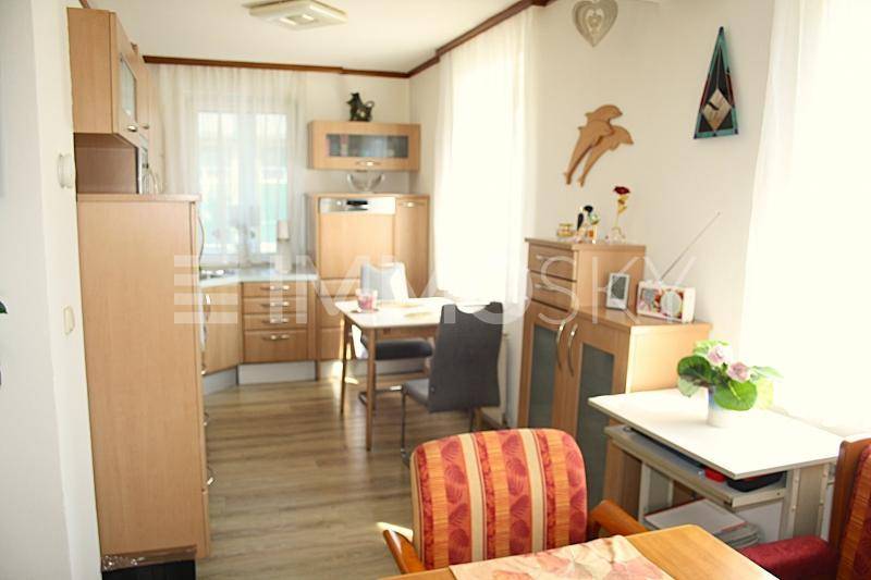 Gemütliche Wohnküche mit Holzschränken, Esstisch und viel Tageslicht.