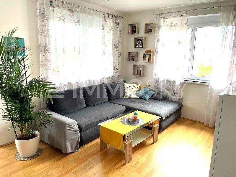 Gemütliches Wohnzimmer mit großem Ecksofa, Holzboden und dekorativen Wandregalen.