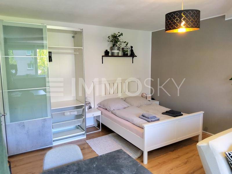 Schlafbereich des Apartments mit Doppelbett, modernem Kleiderschrank und heller Einrichtung.