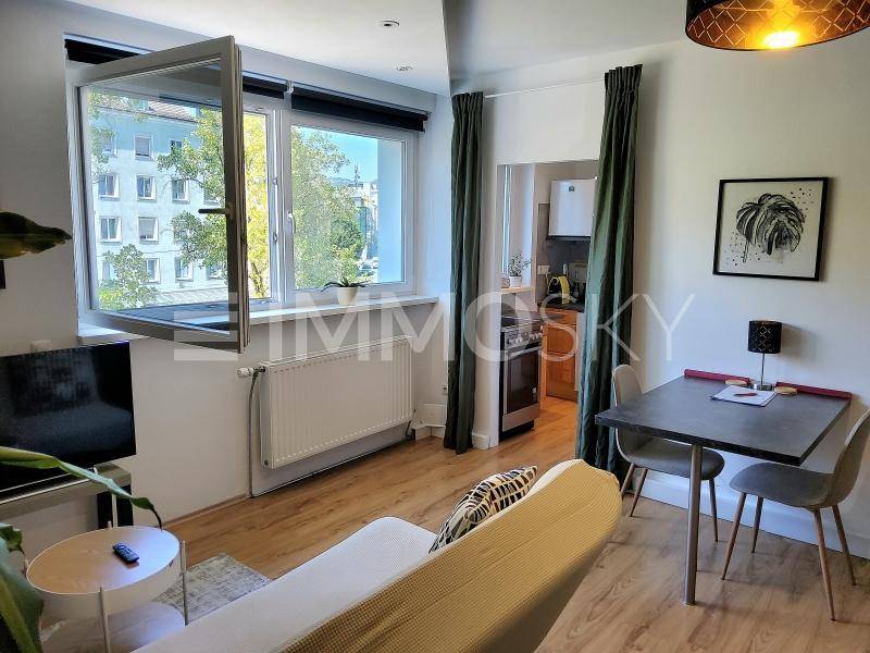 Gemütlicher Wohn- und Essbereich mit Sofa, Esstisch und Blick in die separate Küche.