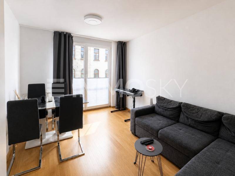 Offener Wohn- und Essbereich mit Sofa, Esstisch und Holzboden.