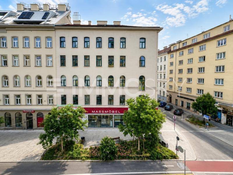 Städtisches Gebäude mit moderner Architektur und Geschäften im Erdgeschoss.