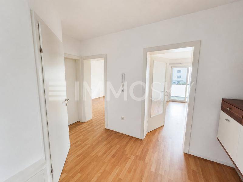 Heller Flur mit Holzparkettboden und mehreren Türen zu angrenzenden Räumen.