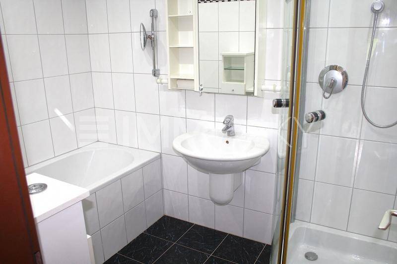 Gefliestes Badezimmer mit Badewanne, Duschkabine und einem einzelnen Waschbecken.