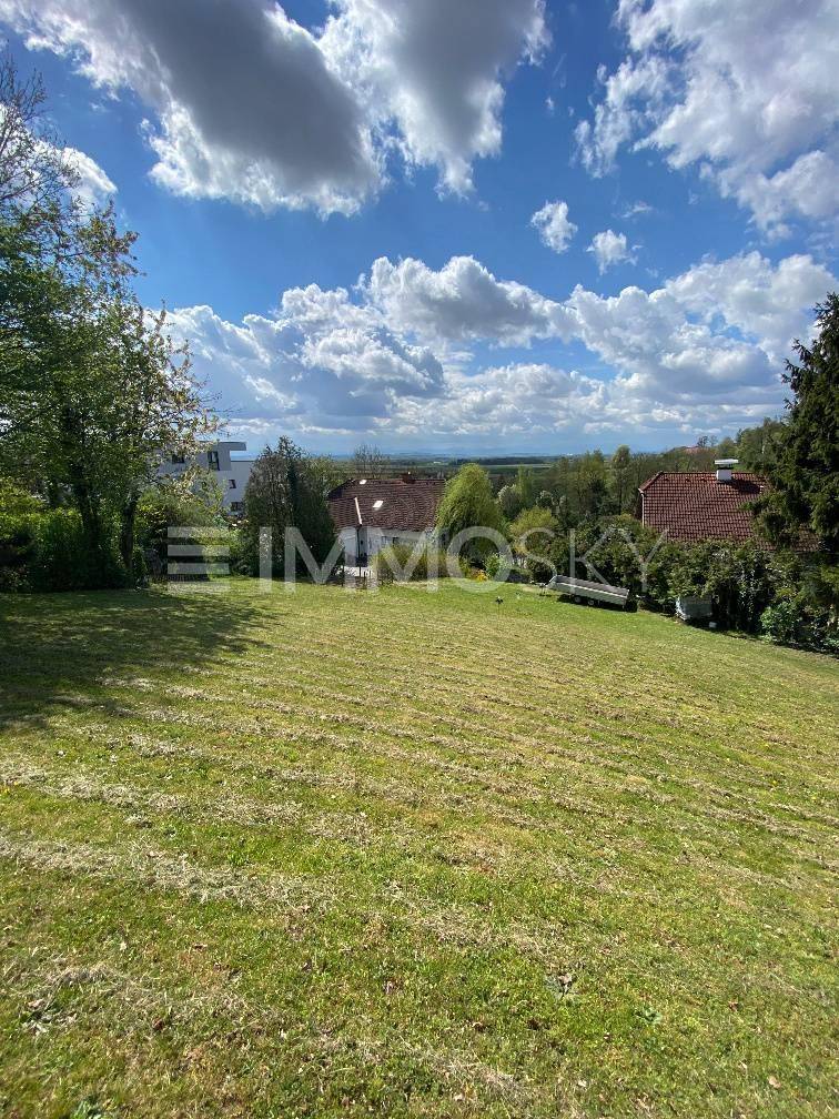 Weitläufiges Grundstück mit Rasenfläche und Panoramablick über die Landschaft.