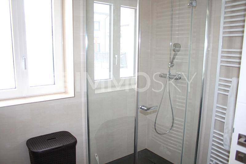 Modernes Badezimmer mit begehbarer Dusche, Fenster und einem praktischen beheizten Handtuchhalter.