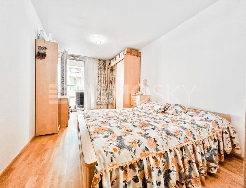 Helles Schlafzimmer mit Holzboden, Doppelbett und direktem Zugang zum Balkon.