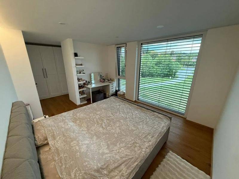 Helles Schlafzimmer mit großem Bett, Einbauschränken und weitem Blick ins Grüne.