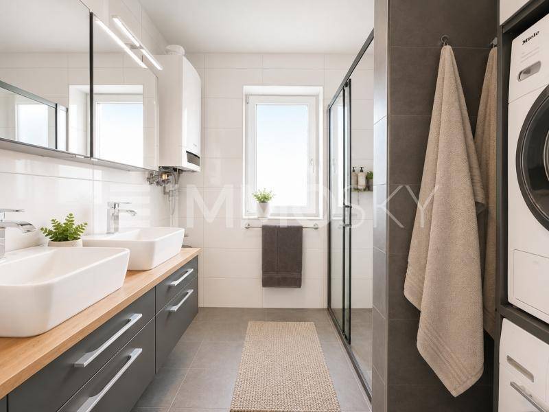 Modernes Badezimmer mit Doppelwaschbecken, begehbarer Dusche und Waschmaschine.