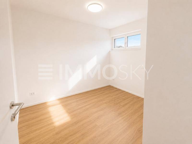 Freundliches Zimmer mit Laminatboden und Fenster, ideal als Kinder- oder Arbeitszimmer nutzbar.