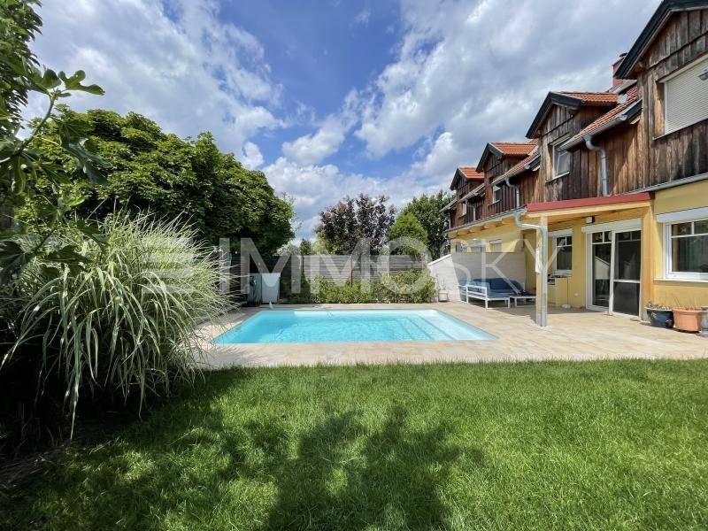 Gepflegter Gartenbereich mit Swimmingpool, Rasenfläche und Terrasse.