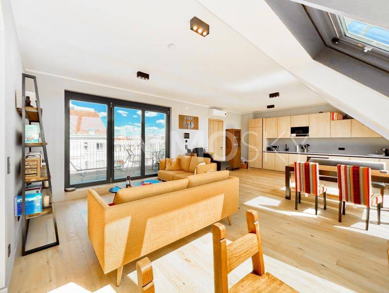 Offener Wohn-Essbereich mit integrierter Küche, gelbem Sofa und Zugang zur Terrasse.