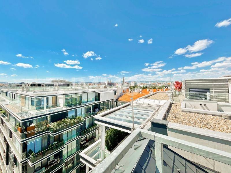 Panoramablick über die Stadt mit modernen Gebäuden, Glasfassaden und einem weiten Horizont.