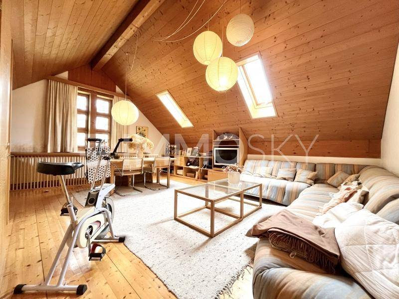 Gemütlicher Dachbodenraum mit Holzverkleidung, Dachfenstern und einem Bereich zum Entspannen und Trainieren.