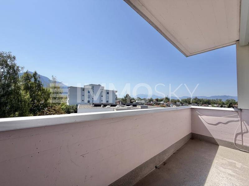 Heller Balkon mit freiem Blick auf die umliegende Landschaft und die Berge.