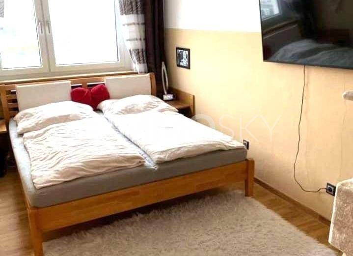 Gemütliches Schlafzimmer mit Doppelbett, Teppichboden und Fenster.