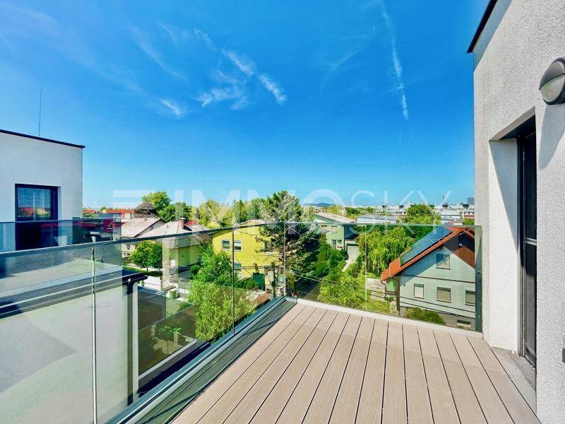 Großzügige Dachterrasse mit Glasgeländer und weitem Blick über die Umgebung.