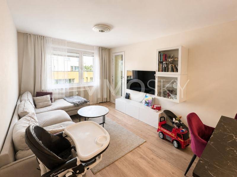 Gemütliches Wohnzimmer mit Sofa, Fernseher und Laminatboden, ideal für Familien.
